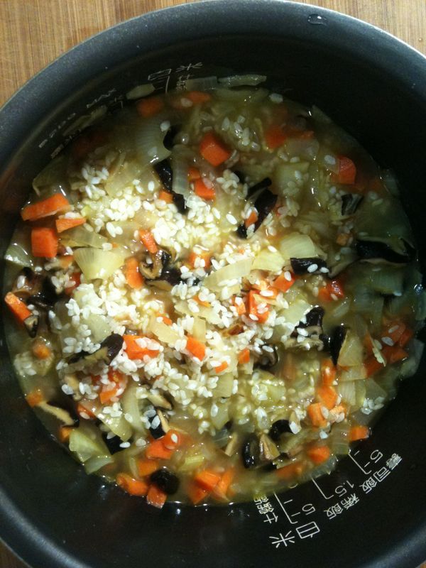 將步驟6放入洗好的白米中，加入步驟3的香菇水，加進穀盛壽喜燒【炊飯用】，再加水至「電子鍋內所標示的煮杯白米的刻度」後，整鍋好料用筷子稍微攪拌均勻。