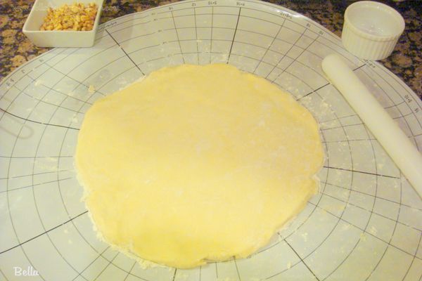 一個小時後，拿一個麵團球出來，放到灑了麵粉的台子上，揉成9 吋 的圓型餅皮，台子上一定要放夠麵粉，不然會很黏，盡量不要用手去摸，麵團溫度越低，越 不黏手。