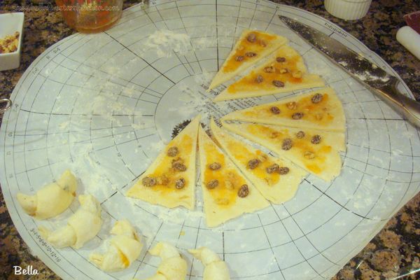 在揉成 圓型的餅皮上抹上約2大匙杏子果醬，再灑上 ½ 杯的內餡，盡量將B料碗底的糖也一起灑上，這樣餅乾會比較香。將麵皮像切蛋糕一樣，切成12等份，從寬的那端用手將三角形往內捲，捲起後彎成牛角型，放入排了烤盤紙的烤盤中，重覆動作將剩餘的麵團做成牛角型後，再將烤盤放入冰箱20分鐘，這樣餅乾比較不會變型。