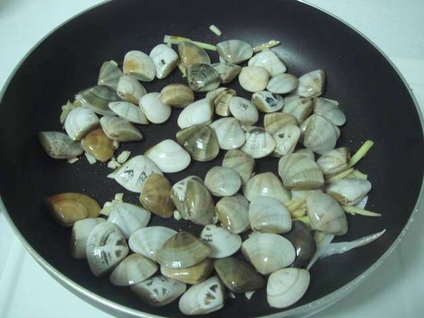 起油鍋，爆香蔥白、蒜末、薑絲，再放入海瓜子略炒。