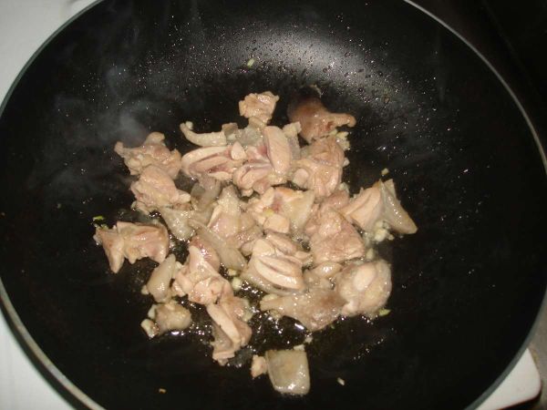 將雞腿肉加入煸香後.再加入蒜末一起拌炒..