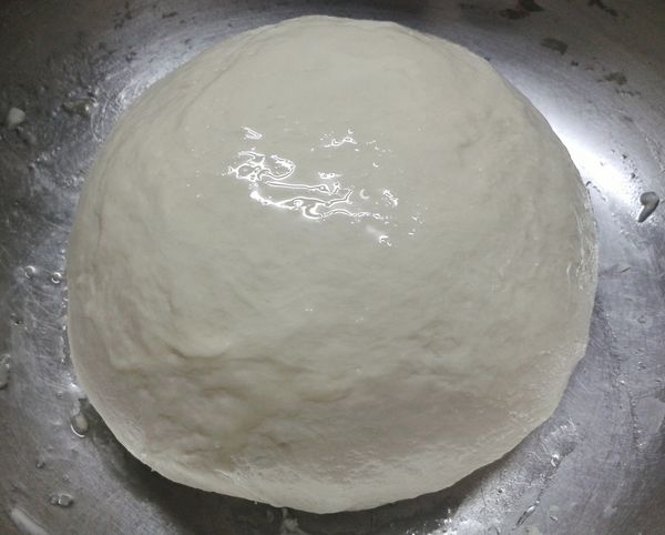 成麵糰後，放在灑有麵粉的枱上，大力搓麵糰約十分鐘至麵糰表面十分平滑。放在塗了油的大碗內，用保鮮紙封口，發酵約一小時至麵糰漲大一倍