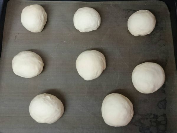 將麵團一個個間隔擺放在已舖有不沾烘培布(紙)的烤盤上，表面噴點水，送進烤箱，做第二次發酵１小時。