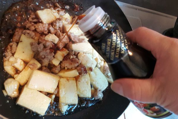 最後把煎好的豆腐和豬絞肉一起拌炒一下，加入適量穀盛壽喜燒、水和蔥花煮滾入味，水稍微收乾即可。