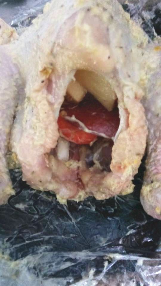 將一部分蘋果、洋蔥、胡蘿蔔及檸檬釀入火雞內，火雞翼尖向後翻，雞下脾用繩縳紮使固定位置