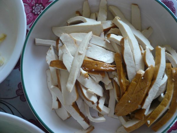 將豆干沖洗一下，切成片再切成絲備用。