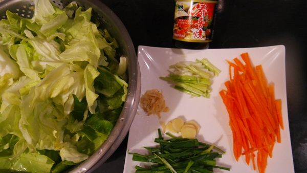 高麗菜清洗乾淨，用手直接掰成片狀，分別把蒜苗、紅蘿蔔清洗乾淨，切絲，蝦皮清洗乾淨備用；