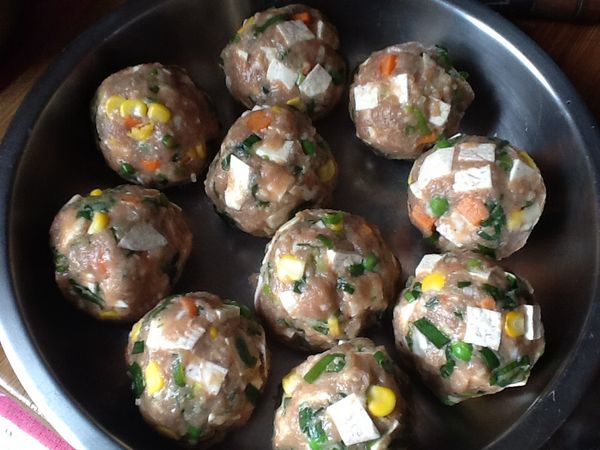 將肉丸子外表再沾綜合蔬菜(紅蘿蔔、玉米、豌豆仁）及另一半的芋頭，整形使其沾黏其上，放入蒸盤。
（也可於步驟4.ㄧ次ㄧ起拌入）