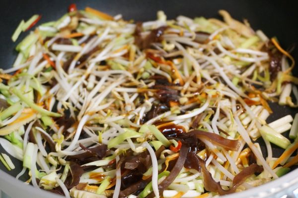 再將韭黃、黑木耳、豆芽及[調味料]一起下鍋翻炒均勻。