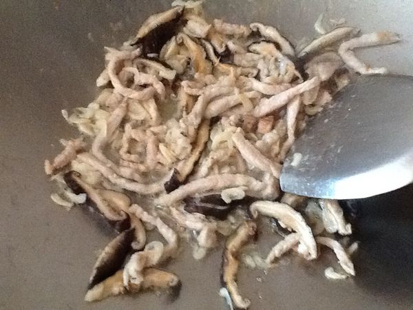 備鍋，放入少許油，熱油後放入肉絲、香菇、蝦皮，先炒香 至肉變白。