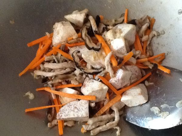 放入芋頭、紅蘿蔔續炒，至芋頭表面微洽。
（或芋頭先炸至半熟，在此步驟加入即可）