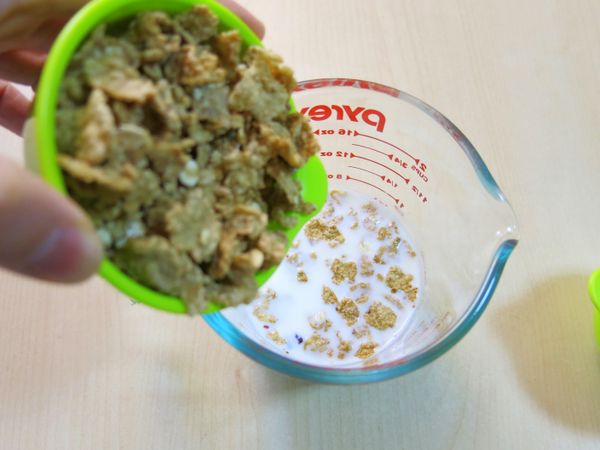 將玉米片與果乾倒在牛奶裡，浸泡熱牛奶裡約10分鐘。