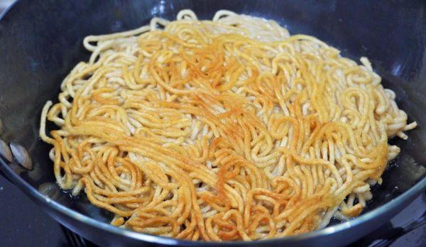 步驟2：
取鍋倒入1大匙豬油熱鍋，油熱後轉小火放入步驟1的熟麵，用鍋鏟壓平成圓餅狀，過程中可再略倒入0.5至1大匙豬油，等小火慢煎至兩面呈現金黃色即可取出備用。