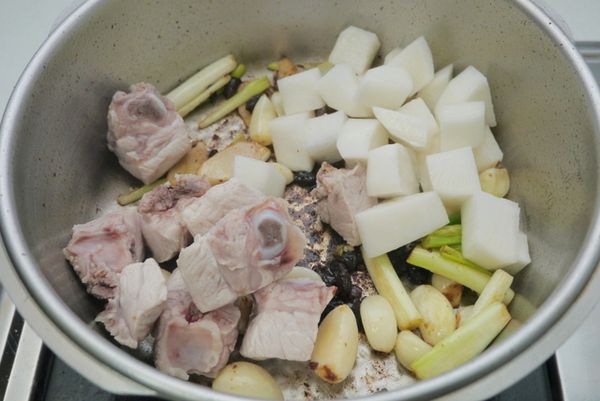 加入子排和白蘿蔔翻炒，再加入醬油、米酒翻炒均勻。