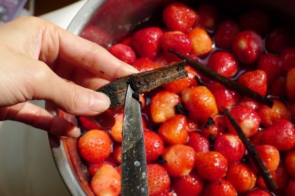 取出糖漬草莓，將香草莢對剖刮取香草籽連同香草莢外皮一起放入鍋內
