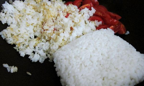 鍋裡的油有點紅時，放入冷飯慢慢撥散。