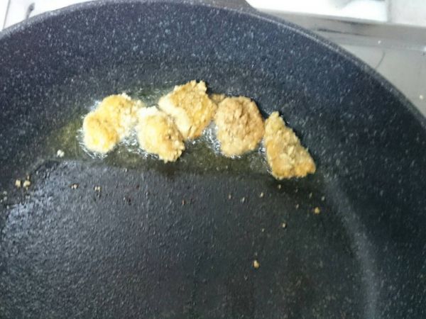 起油鍋，油熱至將筷子插入油中，筷子邊會有泡泡冒出時，就可將雞肉塊放入油炸。（因我不想浪費太多油，故將鍋子拿得有點傾斜，少量多次放入油炸。）炸至雞肉塊每面都呈焦黃色後就可夾起放在廚房紙巾上吸油。最後再放入九層塔葉油炸。