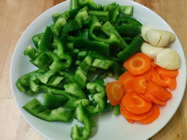 洗淨切好青椒與紅蘿蔔，熱油鍋，蒜頭爆香後放入紅蘿蔔與青椒翻炒