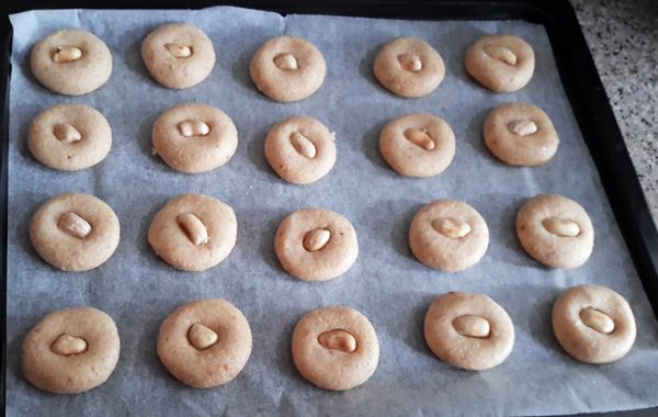 放半粒花生在上，輕輕壓一壓，再在表面塗上蛋黃液