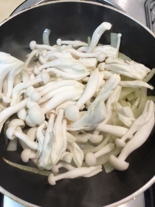 倒入一匙油炒香洋蔥絲.在依序放入美白菇炒一下.加入100CC溫開水