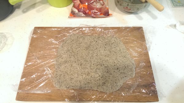 桌灑些許中粉，麵糰正反沾些許，不黏棍，擀平（擀很平為了擠出麵團中的空氣）。