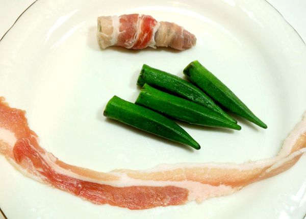 秋葵洗淨後將蒂頭切掉後.用肉片捲起來.