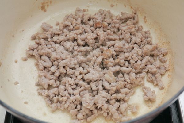 原鍋放入絞肉炒散，再放入蒜末、蔥白爆香。