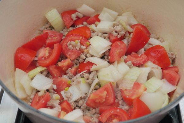 放入洋蔥、牛蕃茄翻炒3∼5分鐘，再加入揉碎的月桂葉和＜調味料＞翻炒均勻，大火煮滾後蓋上鍋蓋，轉小火燜煮15～20分鐘。