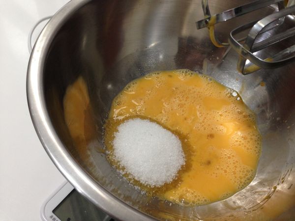 製作巧克力海綿蛋糕。打散的室溫雞蛋裡加入砂糖拌至溶解