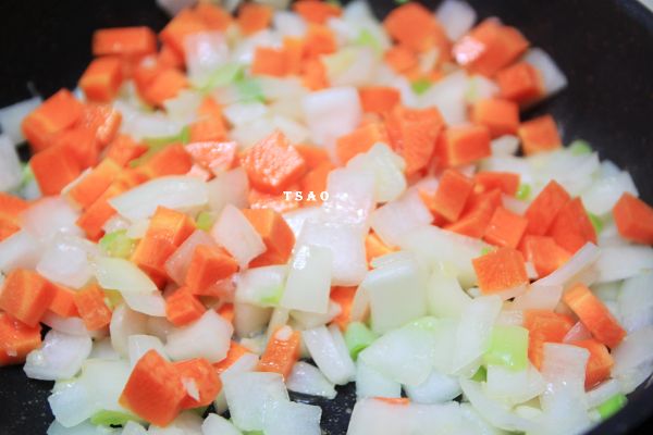 取炒鍋，加少許油依續加入蒜末、蔥白、洋蔥及紅蘿蔔炒香。