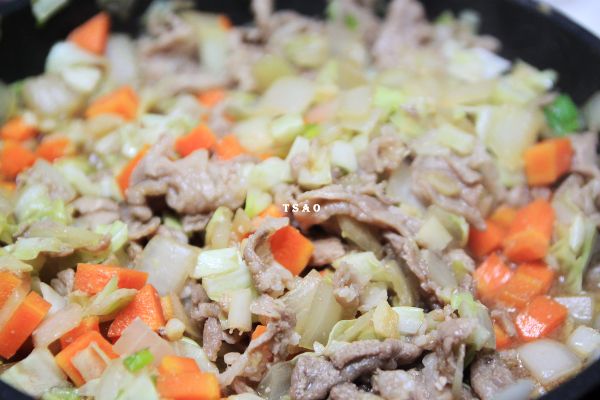 再放入豬肉、高麗菜及調味料拌炒均勻。