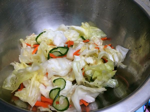 將放置10分鐘後的菜稍微沖一下水洗去多餘的鹽分，一次抓一把慢慢擠出水分。