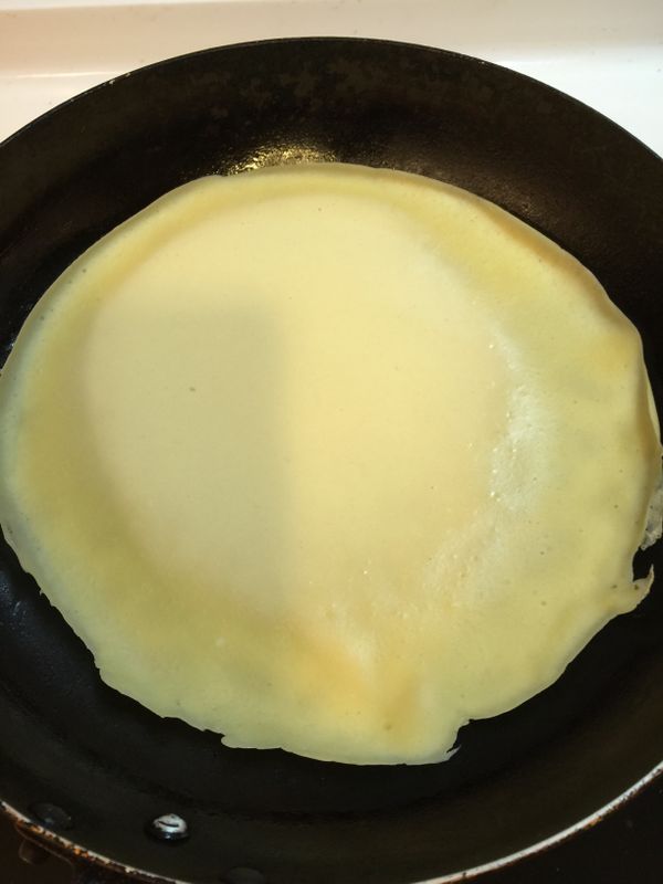 熱鍋中倒入少許油，加入一半的麵糊攤平煎熟後拿起，再倒入另一半麵糊攤餅皮