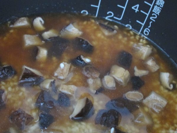 糯米洗淨、香菇切丁，加入滷汁，以香菇水補充至電子鍋內鍋刻度2多一點點~如圖。(以量米杯為準來對應水量需求的刻度~此鍋在最右邊的那條) 按下煮飯開關，等電鍋完成煮飯後開蓋拌一拌，再悶10分鐘即可。