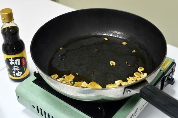炒鍋放富味鄉胡麻油，爆香薑片及蒜頭。