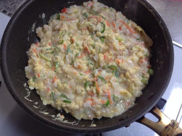 倒入剩下一半的A，再用筷子繞圈子，讓蛋液和白飯充分受熱，約1分鐘後，將四周的凝固的地方往裡面翻動，從右側將飯慢慢翻面堆到左邊的鍋邊，整一整形。