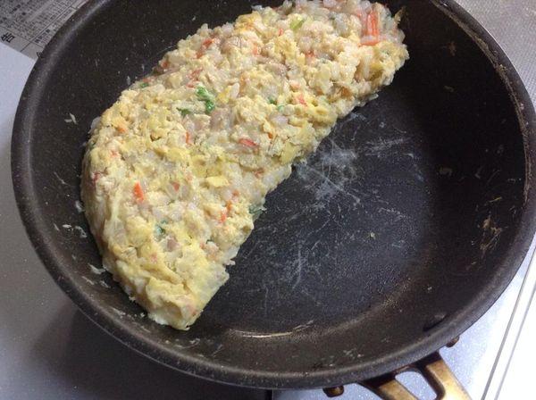 找一個大小合適的盤子，扣在鍋上，然後將飯倒扣至盤子上，再將炒飯滑回鍋中。