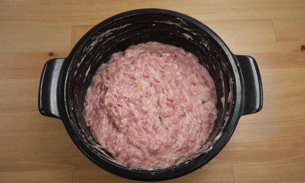 步驟2：
取容器將絞肉、豆腐、山藥泥、1/2薑泥、1/2蔥末、蛋白、太白粉一起攪拌均勻至有黏性，並調入1/2小匙的鹽、白胡椒粉、糖與1.5匙的紹興酒，作成6顆肉丸子備用，取鍋倒入高湯、1匙紹興酒、1/2小匙鹽和糖後加熱，將芽白心洗淨切條狀放入湯中汆燙約10秒撈出瀝乾備用。