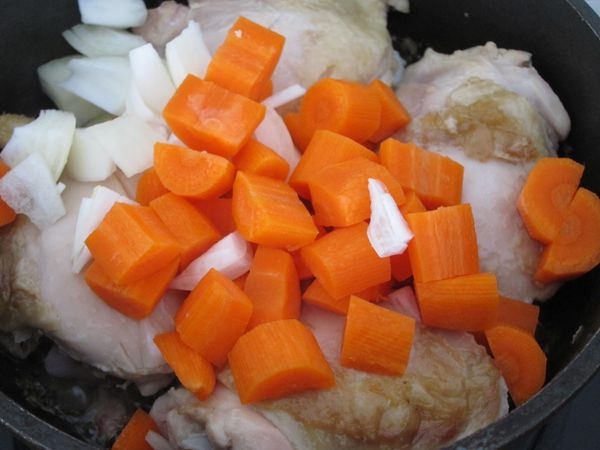 雞肉翻面續煎，並將洋蔥和紅蘿蔔切小塊放入拌炒爆香。