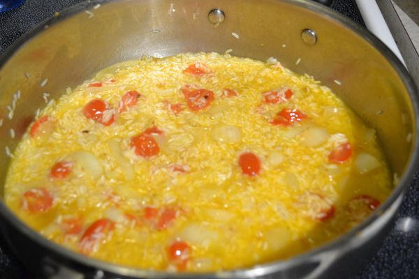 把白飯撲平，倒入鮮雞湯和加入少許海鹽。轉中小火悶飯。