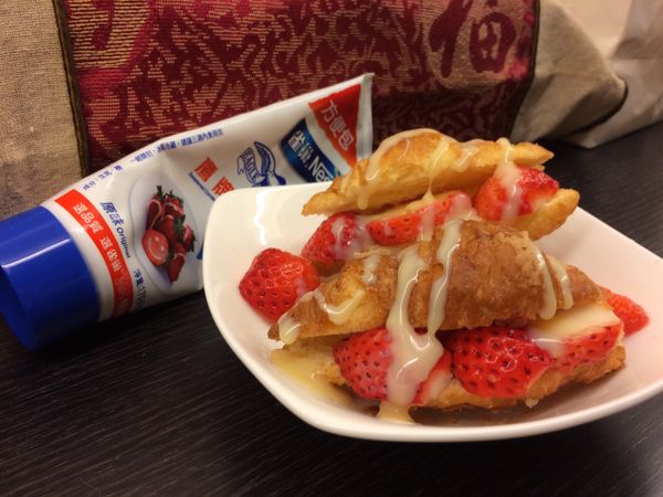 再將可頌麵包對切，放入切半的草莓，最後再淋上煉奶就完成囉!