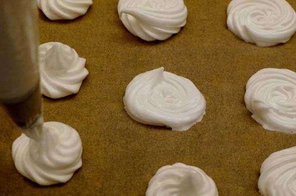 將[蛋白霜]&amp;[可可蛋白霜]分別裝入10mm&amp;5mm星型擠花嘴的擠花袋中，於鋪好烤焙紙的烤盤上擠花