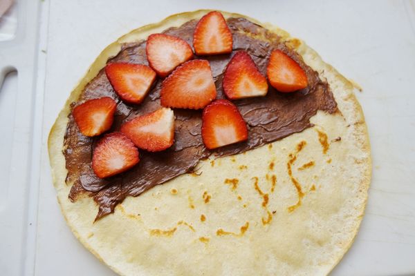 下張餅皮做好也小心移出，這張做甜味的草莓巧克力：餅皮均勻抹上巧克力醬，再放滿新鮮草莓片