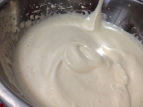 接著準備鮮奶油霜。冰涼的鮮奶油在鋼盆裡高速打發，細砂糖在鮮奶油發起前分次加入