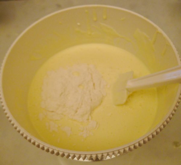 加入過篩後的低筋麵粉，以橡皮刮刀攪拌均勻至看不到粉末