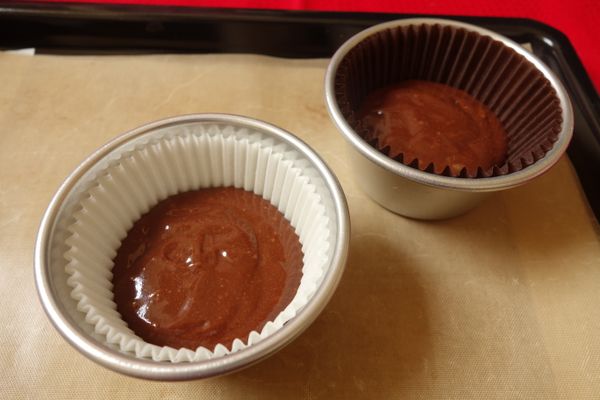 將巧克力蛋糕糊倒進杯子蛋糕模裡，高度大約到模的一半就好