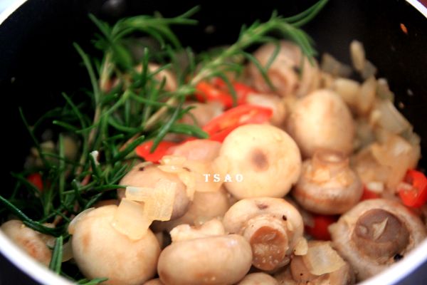 放入迷迭香與蘑菇拌炒一下，再將調味料加入炒勻並稍微收汁即完成。