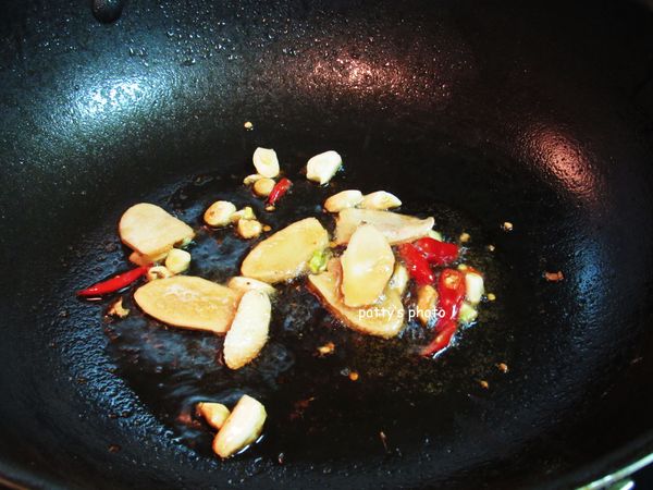 倒出鍋子裡多餘的油，再加入麻油，中火煸蒜、薑、辣椒，至香氣出來。