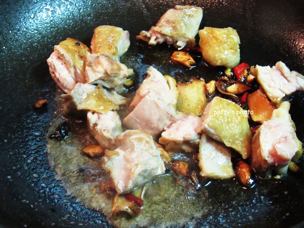 將雞肉放回鍋內，加醬油、米酒拌炒至熟。