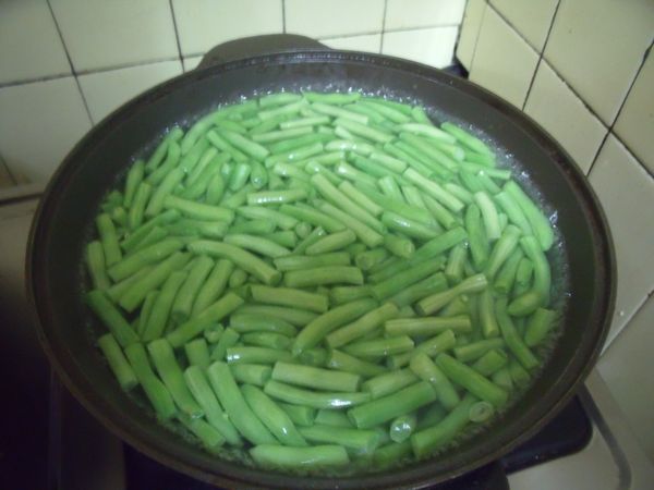 將四季豆去絲,洗淨,切段,鍋中水煮滾,燙熟。